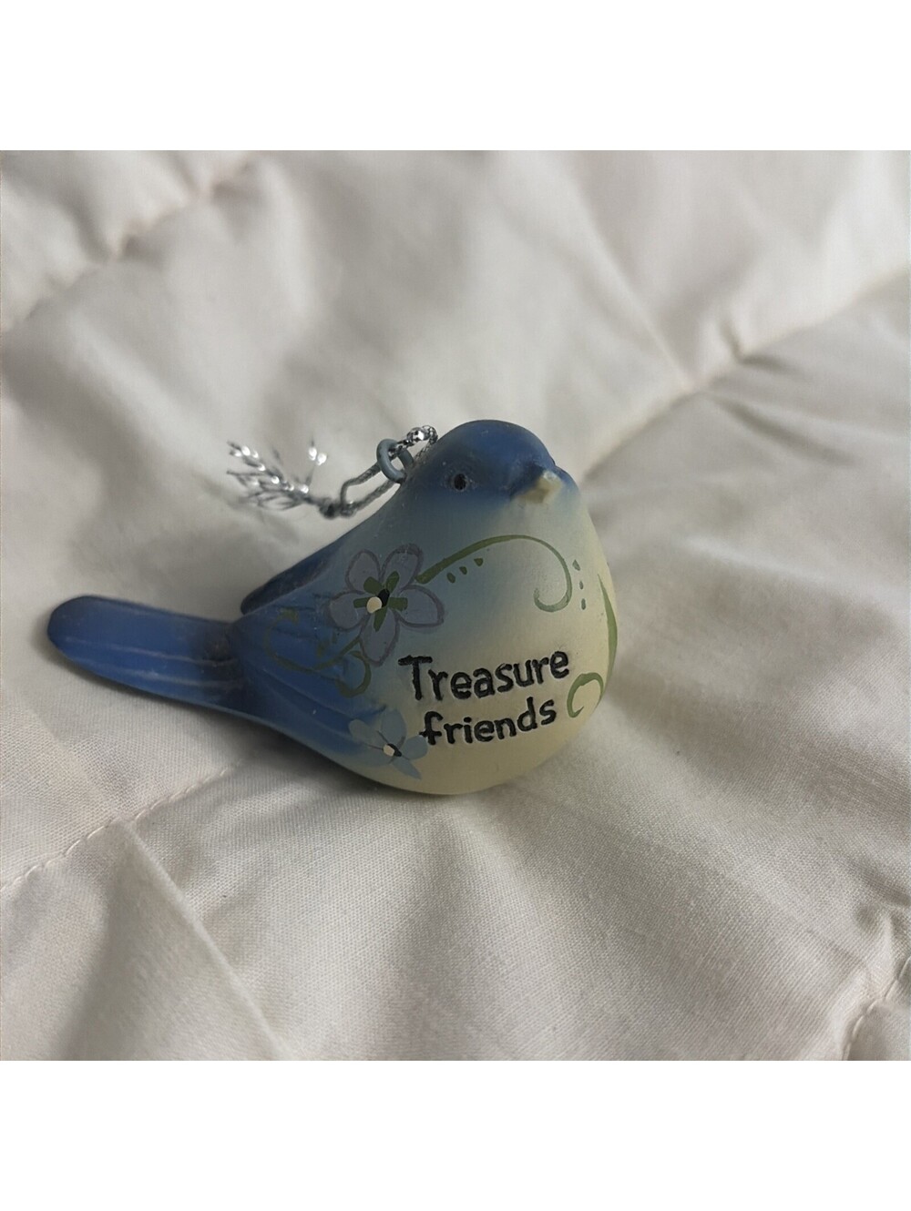 ceramic blue bird ornament features floral accents and the inscription